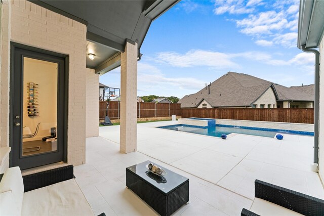 view of patio featuring a fenced backyard and a pool with connected hot tub