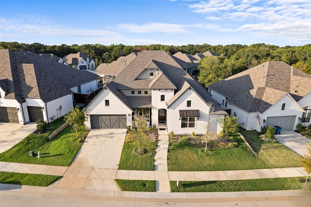 view of front of house with a garage, driveway, roof with shingles, a residential view, and a front yard