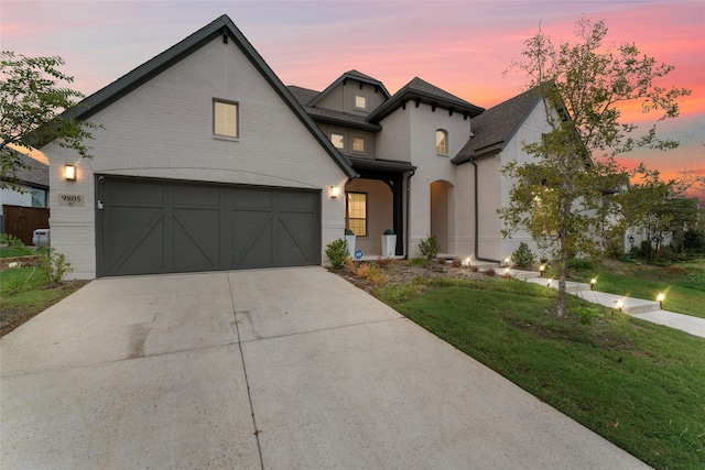 view of front facade featuring a yard, driveway, and brick siding