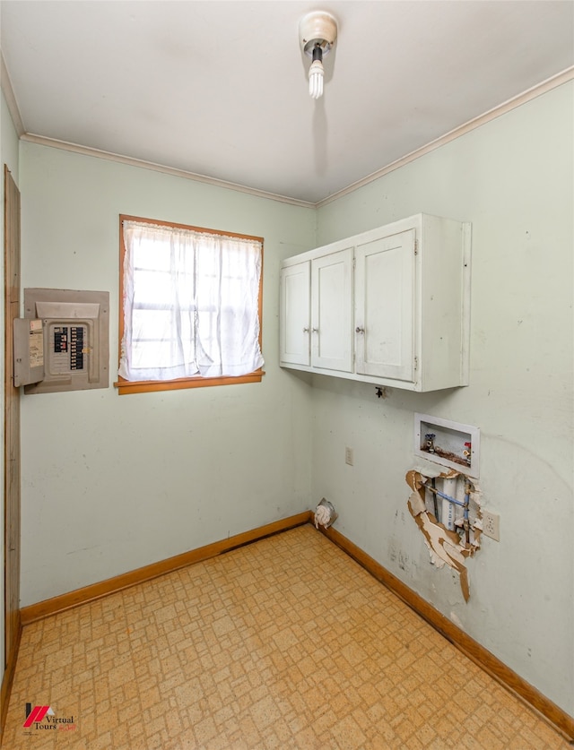 clothes washing area featuring cabinets, ornamental molding, and electric panel