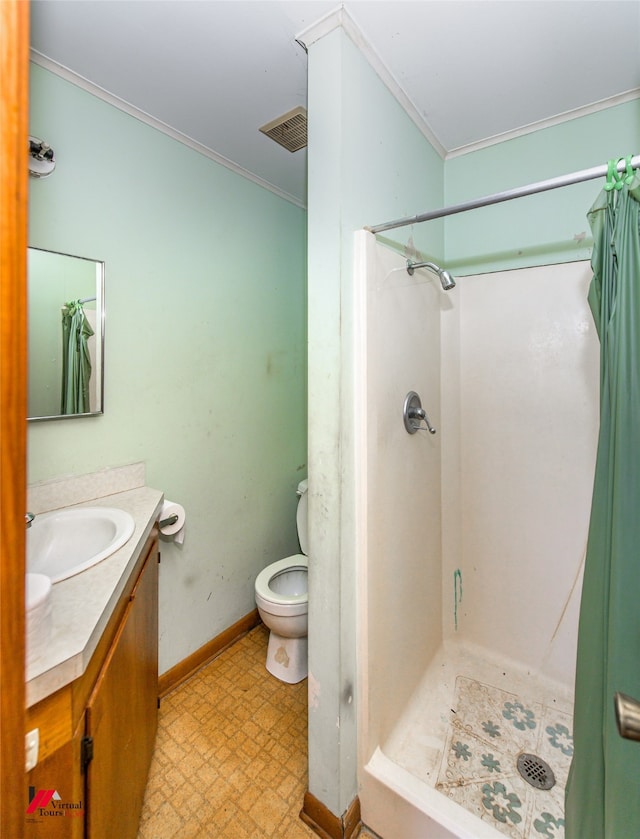 bathroom with vanity, toilet, crown molding, and a shower