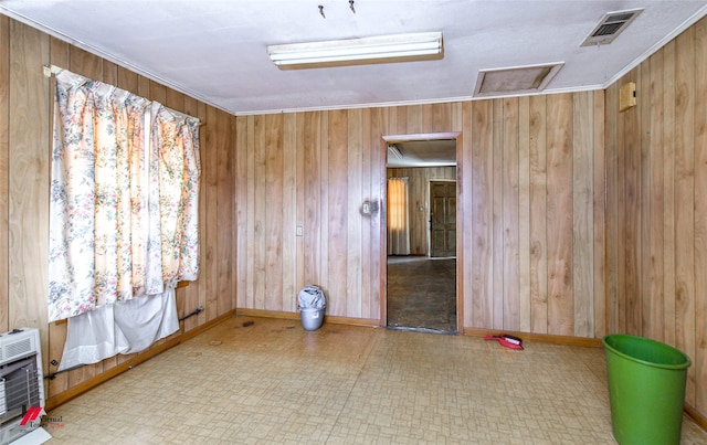 spare room featuring ornamental molding, wood walls, and heating unit