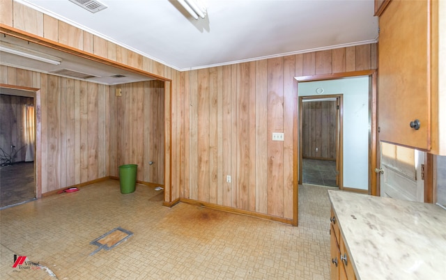 spare room featuring wooden walls and crown molding