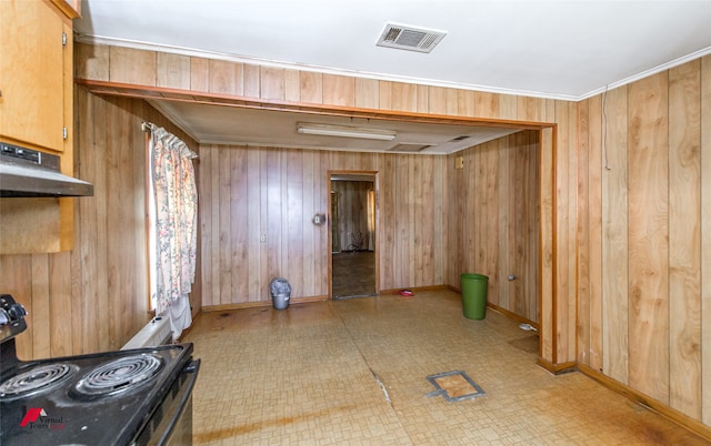 interior space featuring ornamental molding and wooden walls