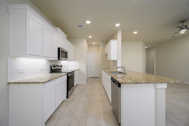 kitchen featuring light stone countertops, kitchen peninsula, white cabinets, and stainless steel appliances