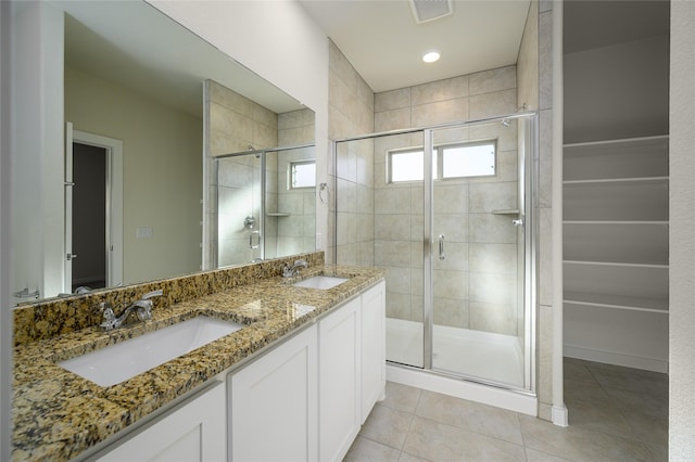 bathroom featuring a shower with door, tile patterned floors, and vanity