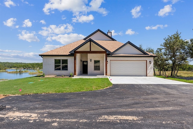 view of front of home with a water view, a front lawn, and a garage