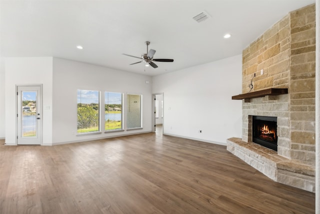 unfurnished living room featuring a fireplace, dark hardwood / wood-style floors, and ceiling fan