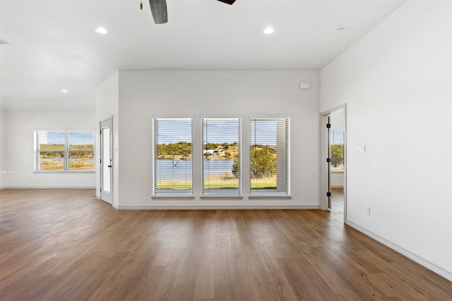 unfurnished living room featuring ceiling fan and hardwood / wood-style flooring