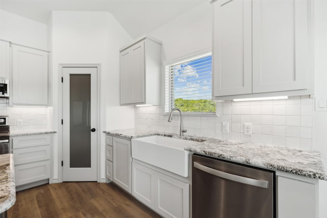 kitchen featuring appliances with stainless steel finishes, sink, dark wood-type flooring, and white cabinets