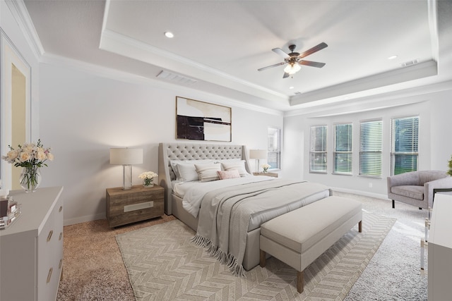 carpeted bedroom featuring crown molding, a raised ceiling, and ceiling fan