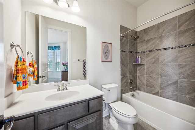 full bathroom featuring tiled shower / bath, vanity, and toilet