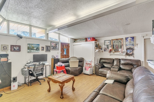 living room featuring a textured ceiling, beamed ceiling, and light hardwood / wood-style flooring