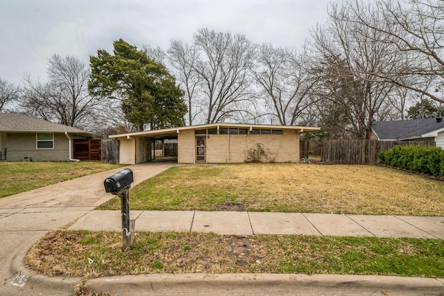 ranch-style home featuring a front lawn and a carport