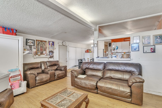 living room with light wood-type flooring and a textured ceiling