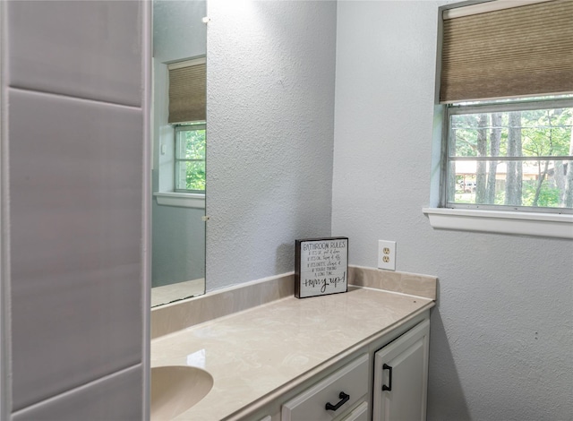 bathroom featuring a textured wall and vanity