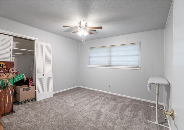 bedroom featuring ceiling fan, a textured ceiling, a closet, and carpet flooring