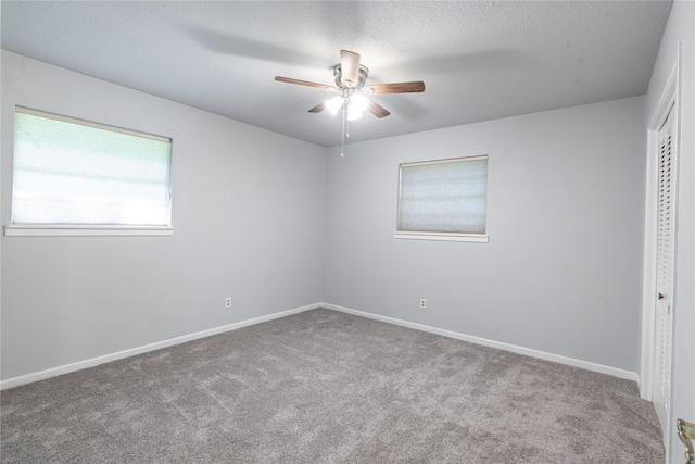 carpeted empty room with a textured ceiling and ceiling fan