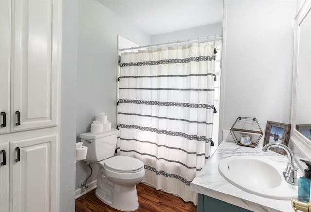 full bath with toilet, vanity, a shower with curtain, wood finished floors, and a textured wall