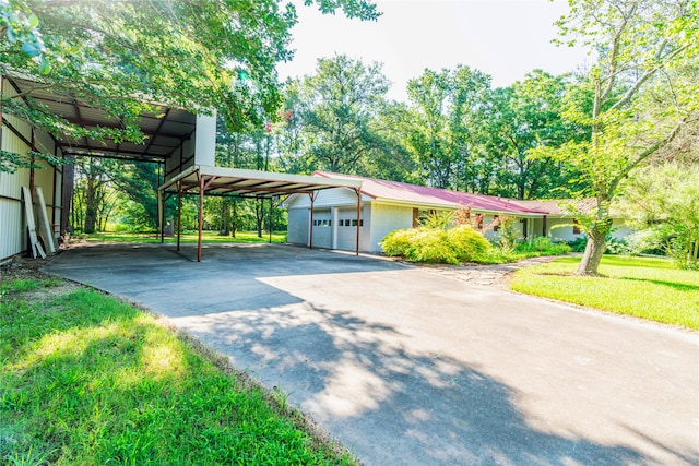 view of front facade with a garage, a carport, and a front lawn