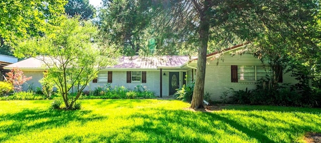 single story home with brick siding and a front yard