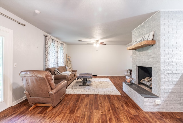 living room with a fireplace, dark hardwood / wood-style floors, and ceiling fan