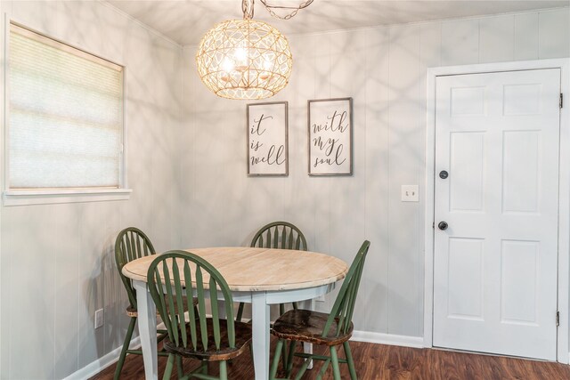 dining area with dark wood-style floors, a notable chandelier, and baseboards