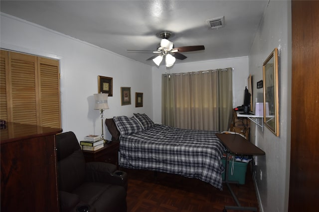 bedroom with ceiling fan and dark parquet floors