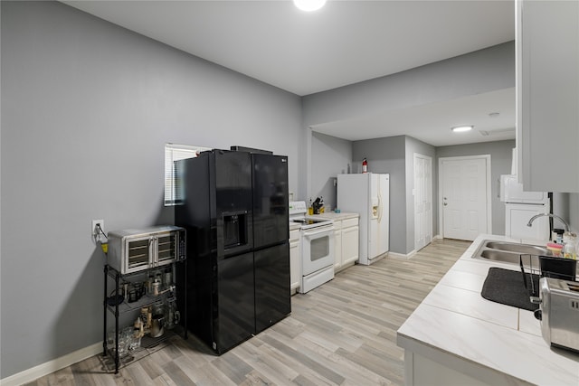 kitchen with white appliances, white cabinetry, sink, and light hardwood / wood-style floors