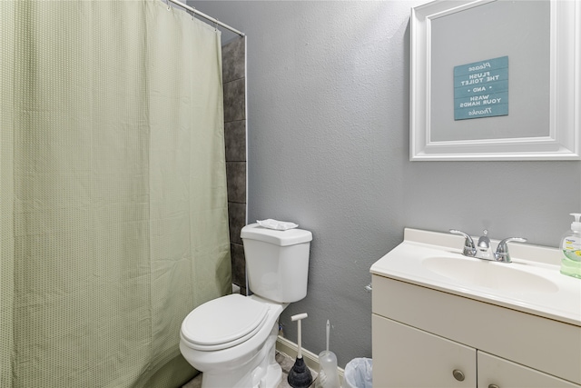 bathroom with toilet, vanity, and curtained shower