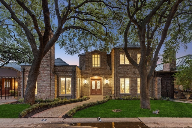 view of front of home featuring a lawn and french doors