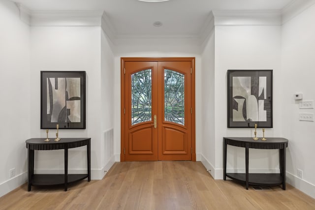 entryway featuring ornamental molding, light hardwood / wood-style floors, and french doors