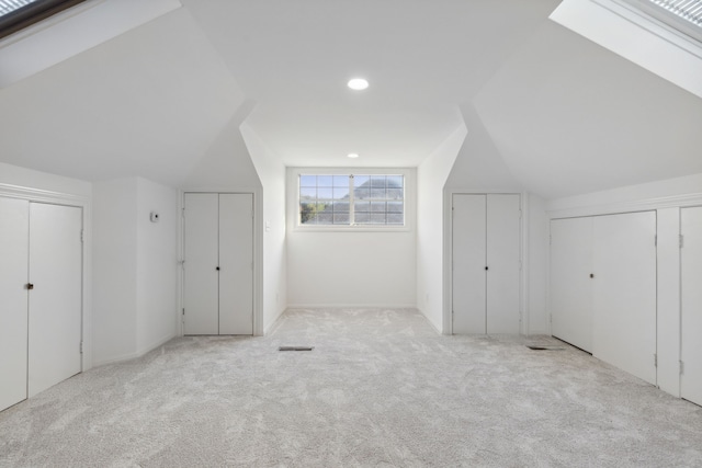 bonus room with lofted ceiling and light colored carpet