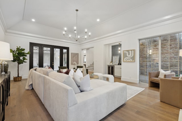 living room with wine cooler, vaulted ceiling, a chandelier, crown molding, and light hardwood / wood-style flooring