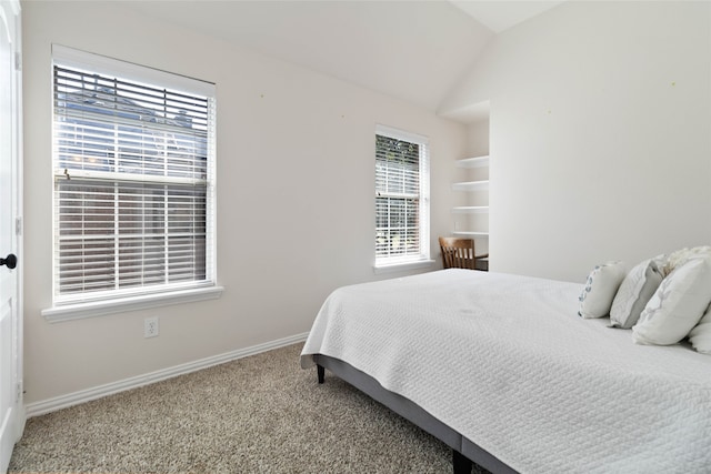 carpeted bedroom featuring vaulted ceiling and multiple windows