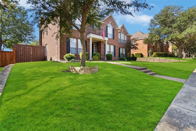 view of front of house with a balcony and a front yard