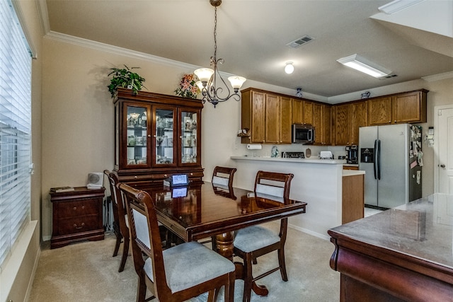 carpeted dining room featuring ornamental molding and a chandelier