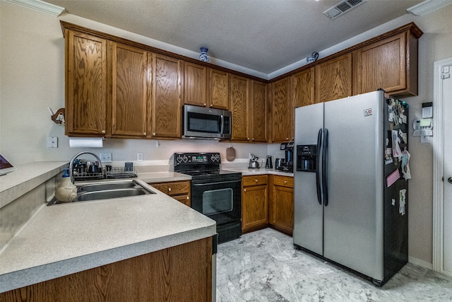 kitchen with a textured ceiling, stainless steel appliances, crown molding, and sink