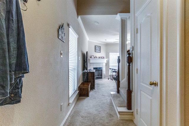 hallway with crown molding and light carpet