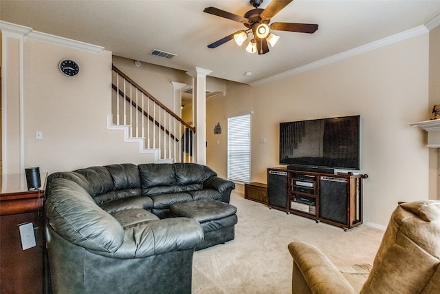 living room featuring carpet, crown molding, ceiling fan, and ornate columns