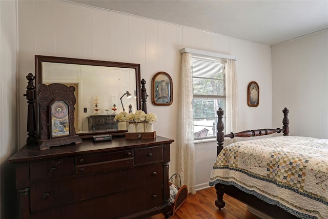 bedroom featuring wooden walls and hardwood / wood-style flooring