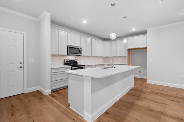 kitchen with decorative light fixtures, sink, white cabinets, a kitchen island with sink, and stainless steel appliances