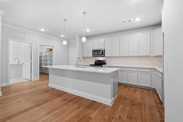 kitchen with electric range oven, hanging light fixtures, sink, and white cabinets