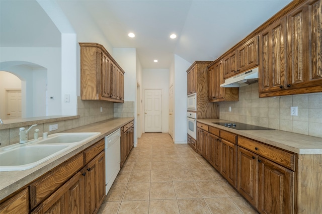 kitchen with backsplash, white appliances, light tile patterned flooring, and sink