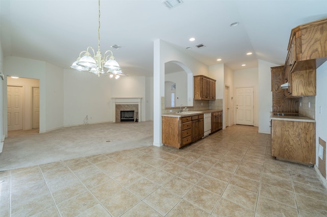 kitchen with tasteful backsplash, dishwasher, light tile patterned floors, and a notable chandelier