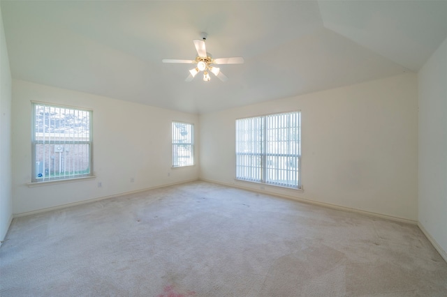 carpeted spare room with ceiling fan and lofted ceiling