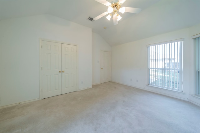 unfurnished bedroom featuring ceiling fan, lofted ceiling, and light carpet