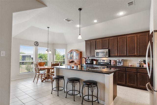 kitchen featuring sink, an island with sink, vaulted ceiling, hanging light fixtures, and stainless steel appliances