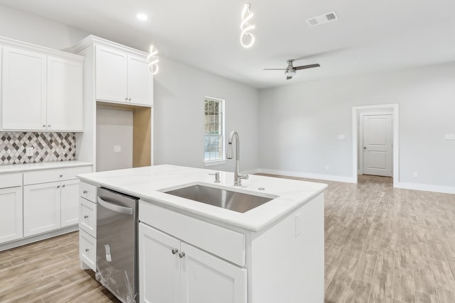 kitchen with dishwasher, ceiling fan, white cabinetry, and sink