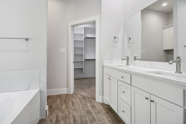 bathroom featuring vanity, hardwood / wood-style flooring, and a tub